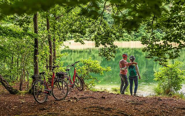 Radfahrer machen Pause und schauen auf den Trünnensee